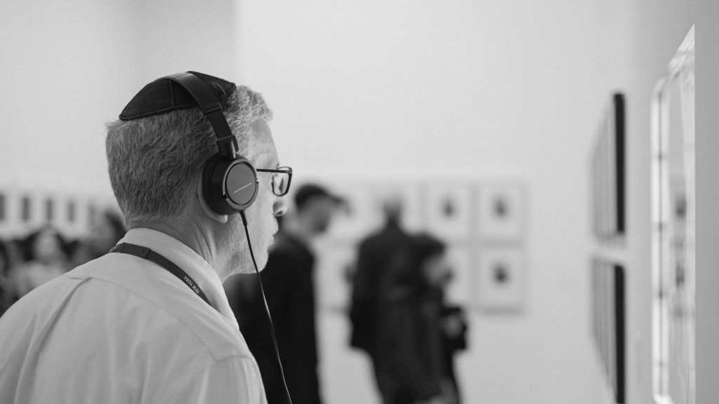 A man listening to audio description in a museum