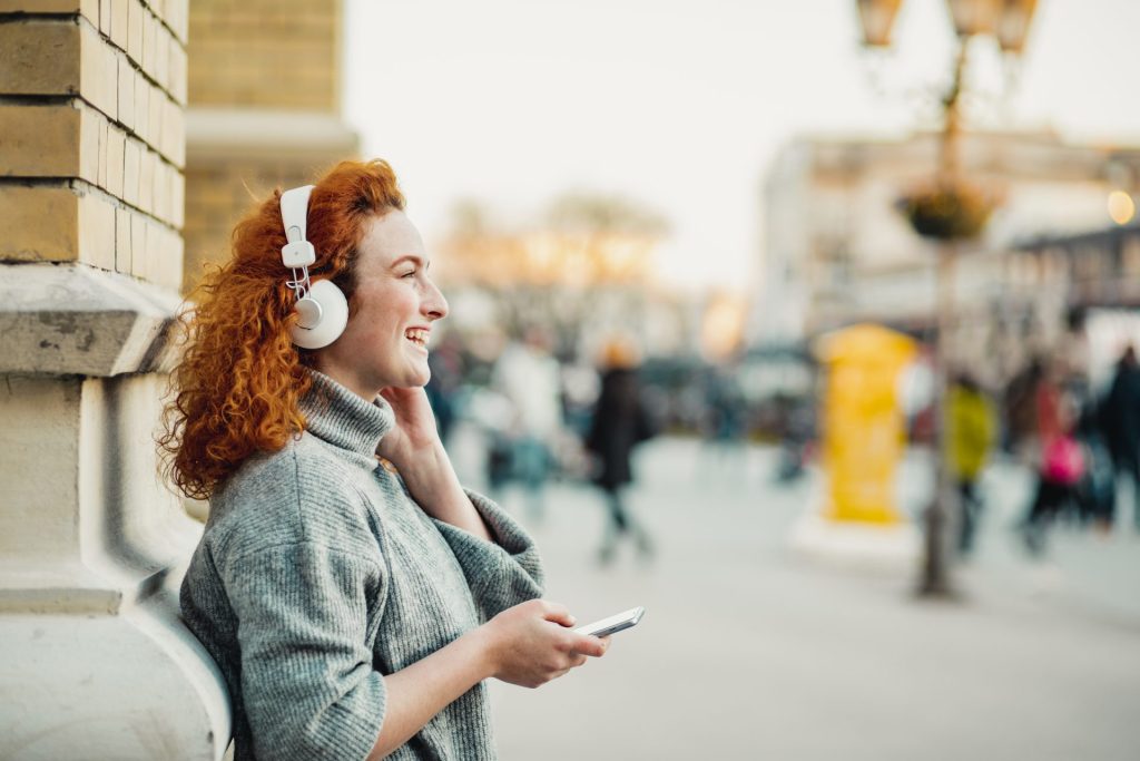 a woman listening to podcast using headphones
